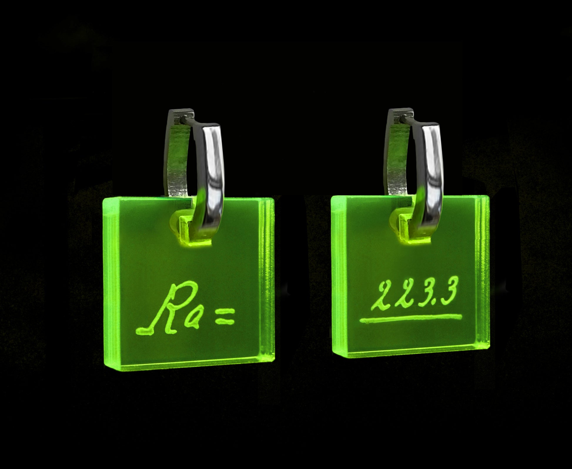 Neon acrylic earrings engraved with Marie Curie’s handwriting and the atomic weight of radium, with stainless steel leverbacks.