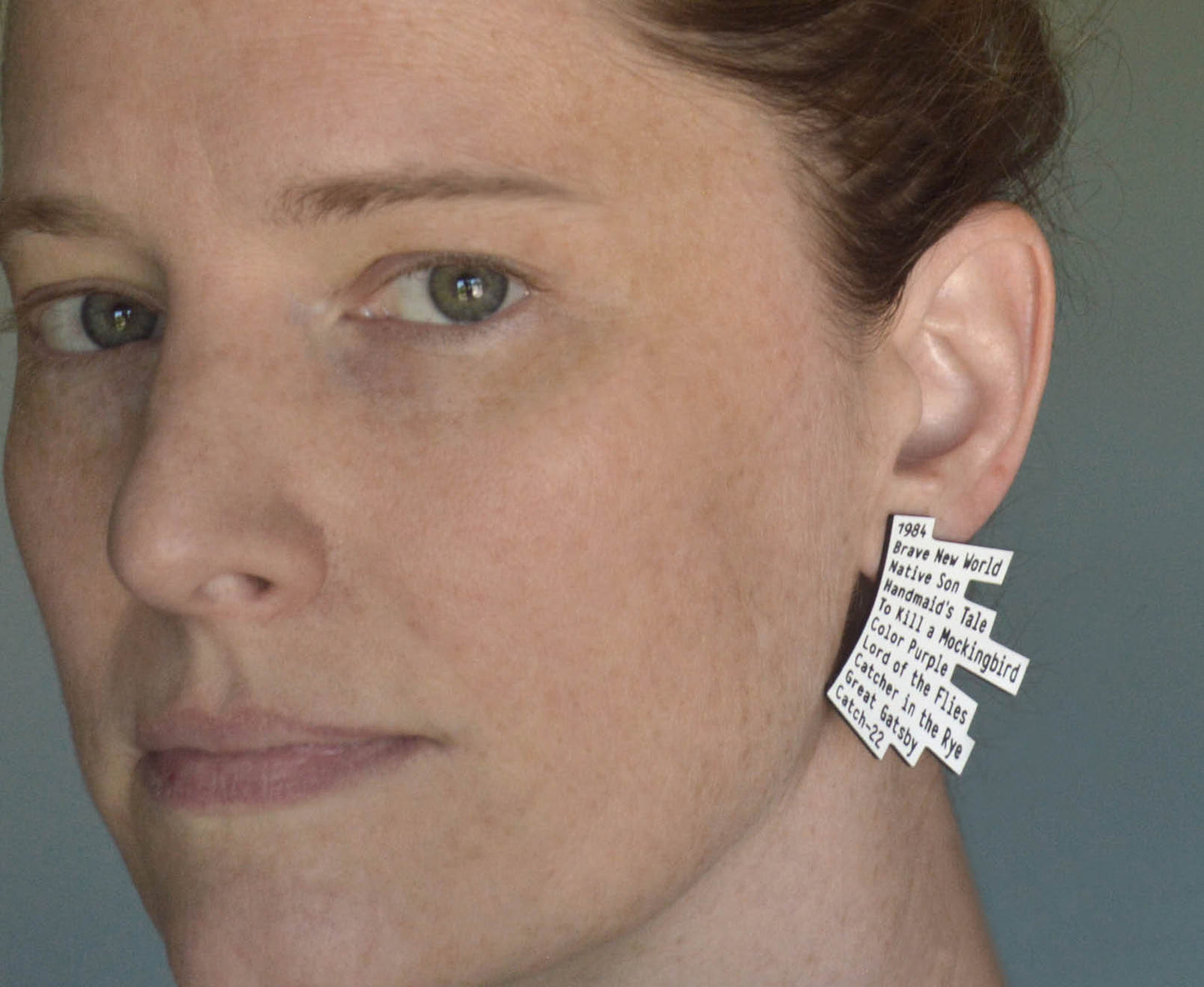 Acrylic stud earrings with engraved book titles, shaped like offset layers of stacked books
