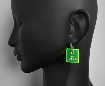 Neon acrylic earrings engraved with Marie Curie’s handwriting and the atomic weight of radium, with stainless steel leverbacks, on mannequin.