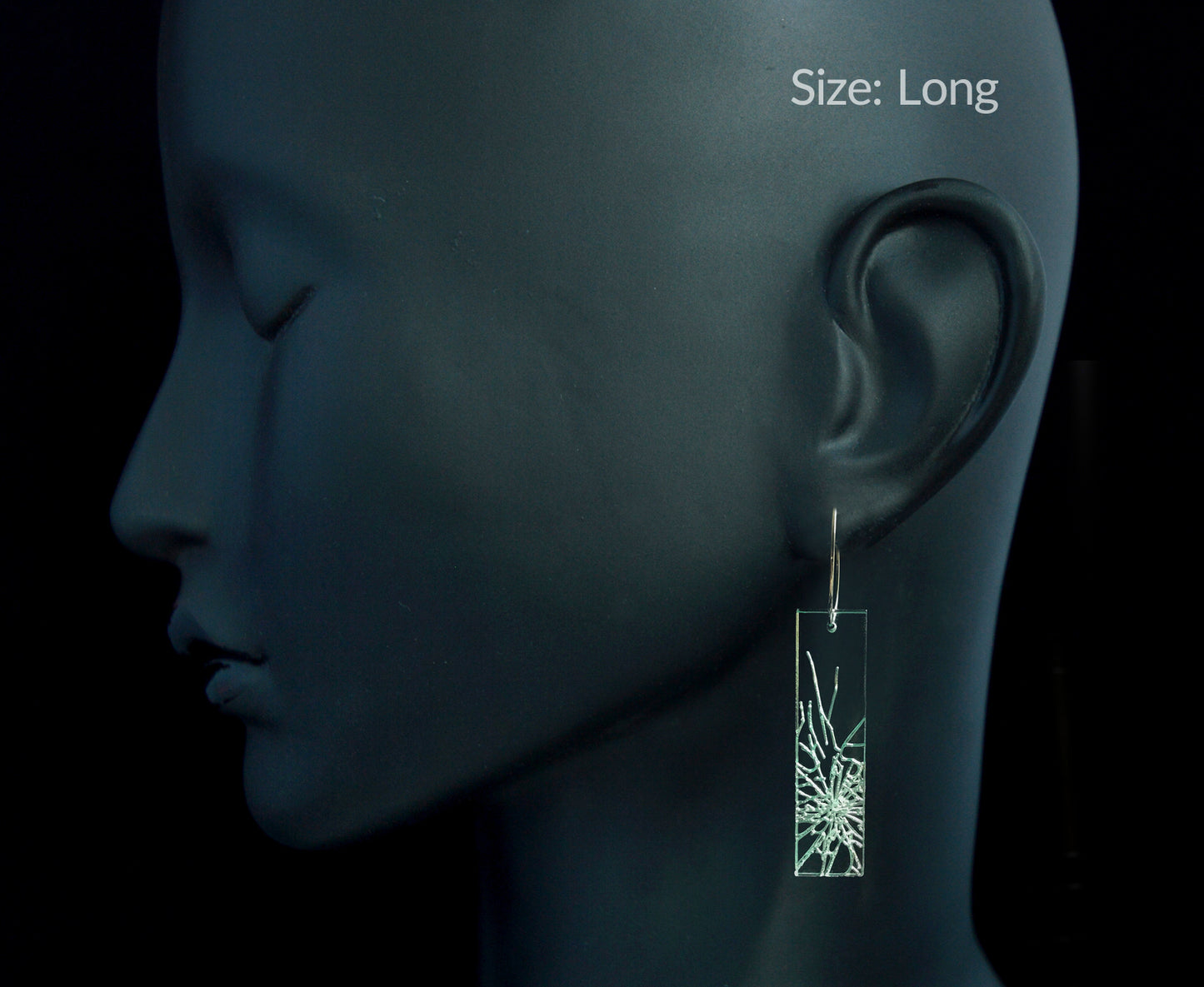 Laser-cut earrings in a shattered glass shape symbolizing gender equality, long rectangle style on mannequin head.